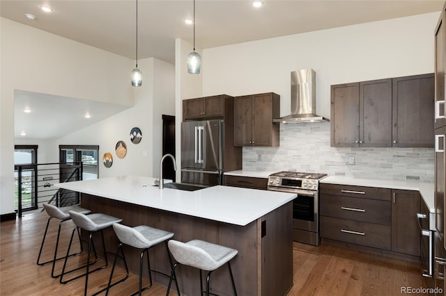 17 Vendette Rd, Silverthorne, CO 80498 - kitchen with wall chimney exhaust hood, stainless steel appliances, a sink, a breakfast bar, and recessed lighting