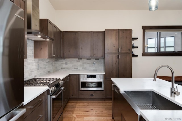 17 Vendette Rd, Silverthorne, CO 80498 - kitchen with appliances with stainless steel finishes, wall chimney exhaust hood, a sink, dark brown cabinetry, and light countertops