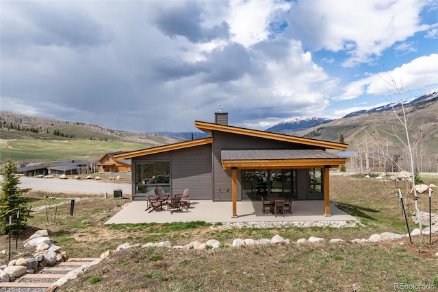17 Vendette Rd, Silverthorne, CO 80498 - back of property featuring a patio, a mountain view, a chimney, and a sunroom