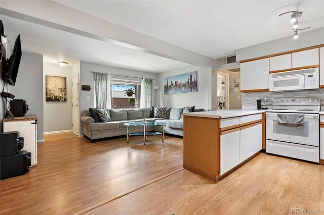 3663 S Sheridan Blvd Unit O15, Denver, CO 80235 - kitchen featuring white appliances, a peninsula, open floor plan, white cabinets, and decorative backsplash