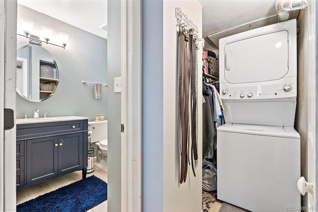 3663 S Sheridan Blvd Unit O15, Denver, CO 80235 - laundry area featuring stacked washer / dryer and light wood finished floors