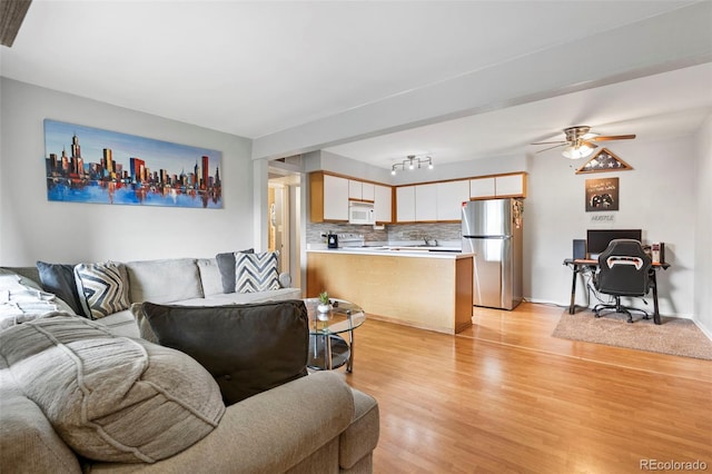 3663 S Sheridan Blvd Unit O15, Denver, CO 80235 - living area featuring light wood-style floors, a desk, and a ceiling fan