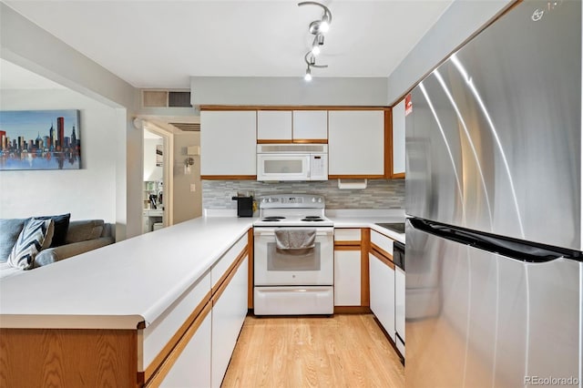 3663 S Sheridan Blvd Unit O15, Denver, CO 80235 - kitchen with white appliances, white cabinetry, light countertops, decorative backsplash, and light wood finished floors