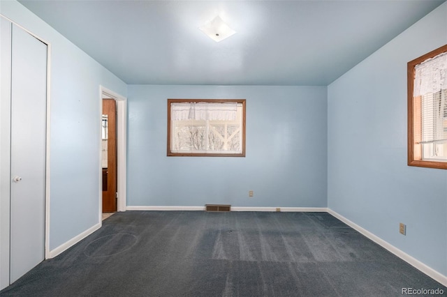 unfurnished bedroom with dark carpet