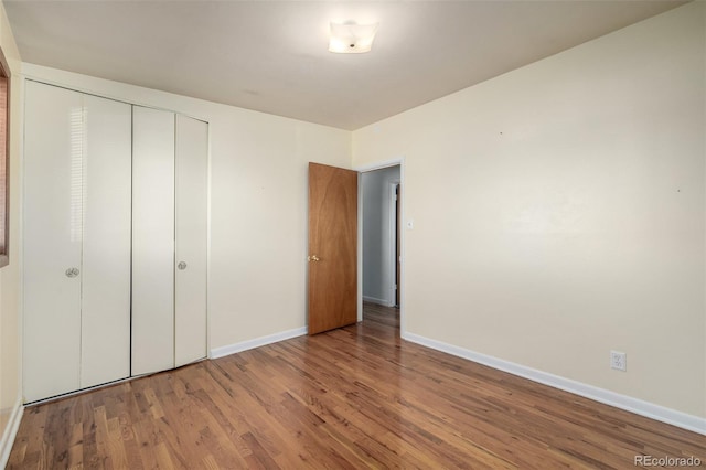 unfurnished bedroom with hardwood / wood-style flooring and a closet