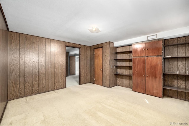 unfurnished bedroom with light carpet and wooden walls