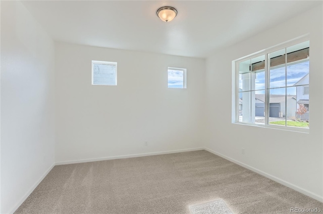 spare room with baseboards and carpet