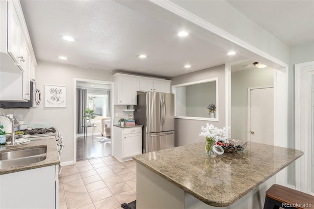 kitchen with recessed lighting, stainless steel appliances, light stone counters, and white cabinets