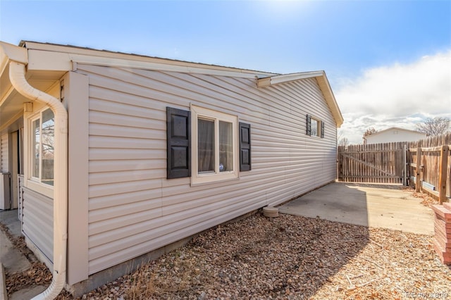 view of side of home featuring a patio area and fence