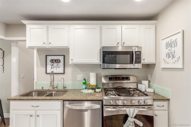 kitchen with appliances with stainless steel finishes, white cabinetry, and a sink