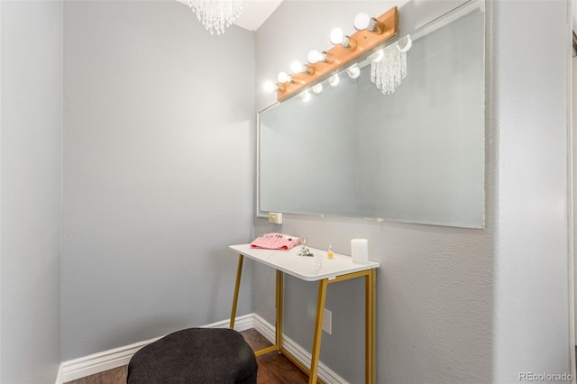 bathroom with a notable chandelier, baseboards, and wood finished floors