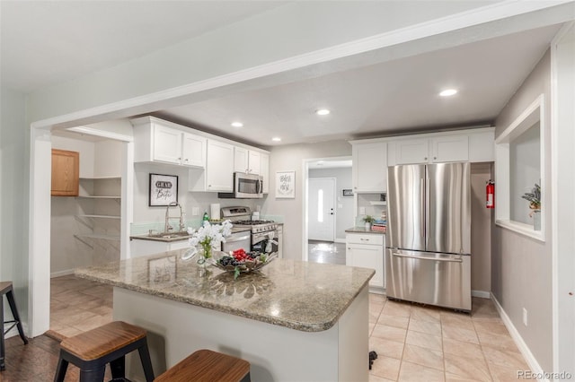 3541 E 118th Ave, Thornton, CO 80233 - kitchen with stainless steel appliances, white cabinets, light stone countertops, a kitchen breakfast bar, and recessed lighting