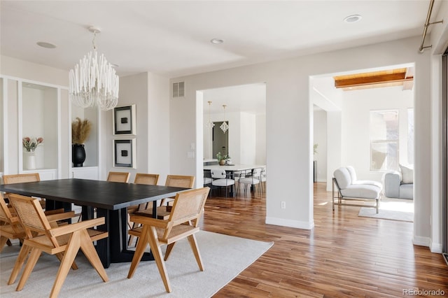 dining area with a chandelier, recessed lighting, wood finished floors, visible vents, and baseboards