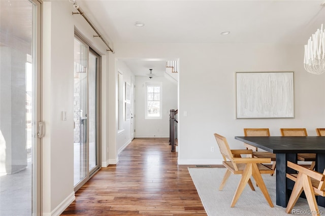 dining space with baseboards, wood finished floors, and recessed lighting