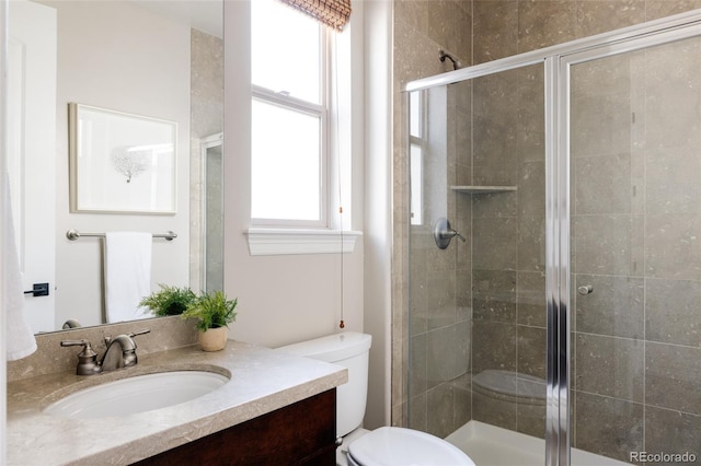 full bath with a stall shower, vanity, and toilet