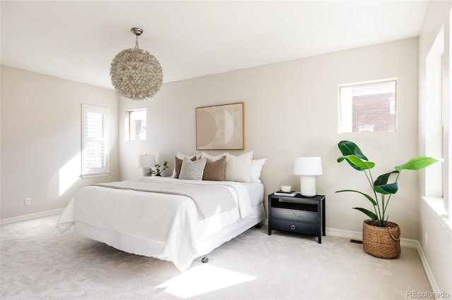 bedroom with baseboards and light colored carpet