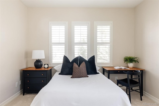 bedroom with light carpet and baseboards