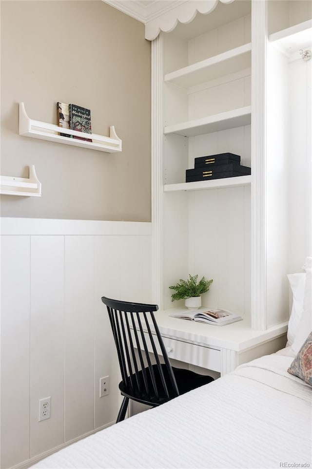 bedroom with a decorative wall and wainscoting