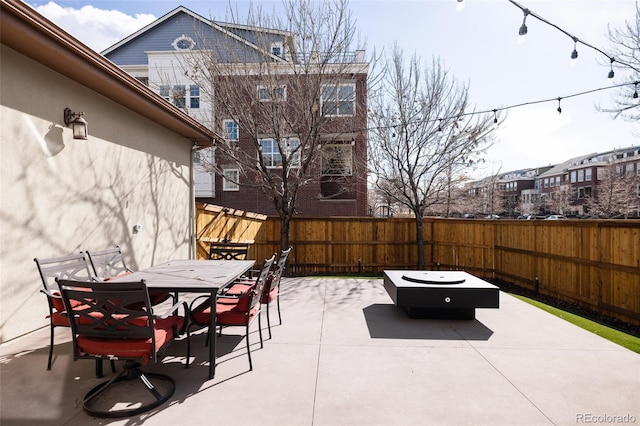 view of patio featuring a fenced backyard, a fire pit, and outdoor dining area