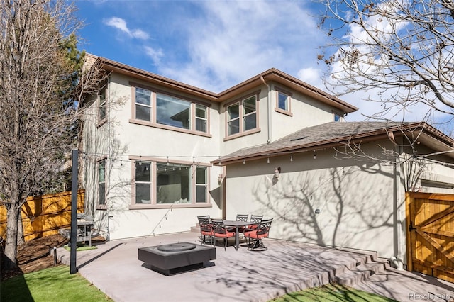 back of house with an outdoor fire pit, fence, a patio, and stucco siding