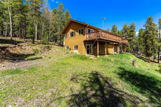 back of house with a wooden deck and a yard