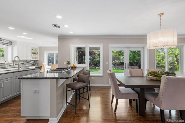 172 S Forest St, Denver, CO 80246 - kitchen featuring a sink, stainless steel gas cooktop, a center island, a kitchen bar, and crown molding