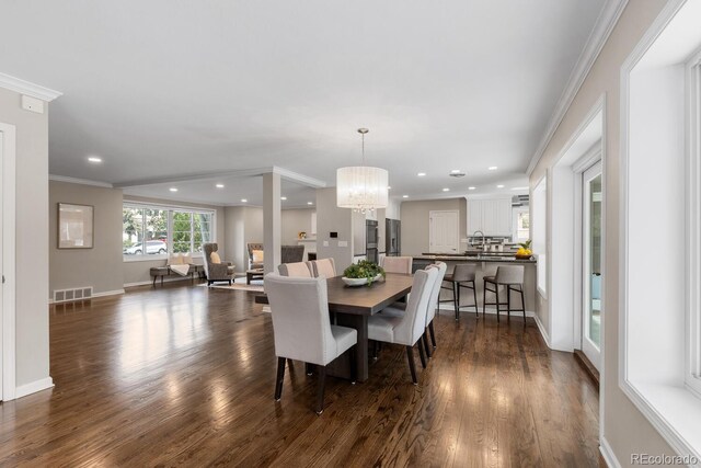 172 S Forest St, Denver, CO 80246 - dining room with dark wood-style floors, a chandelier, recessed lighting, crown molding, and baseboards