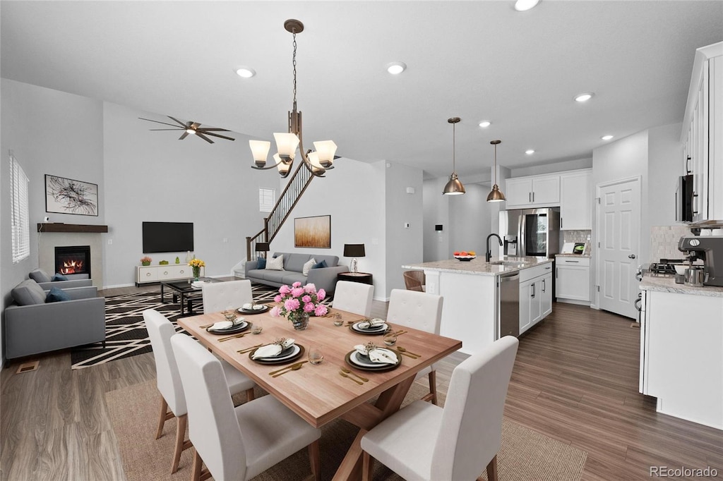 dining room featuring sink, dark hardwood / wood-style floors, and ceiling fan with notable chandelier