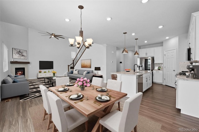 dining room featuring sink, dark hardwood / wood-style floors, and ceiling fan with notable chandelier