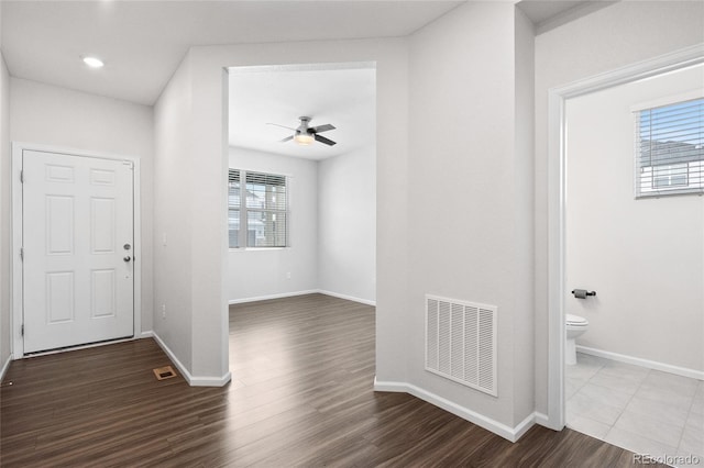 foyer entrance featuring dark wood-type flooring, ceiling fan, and a healthy amount of sunlight