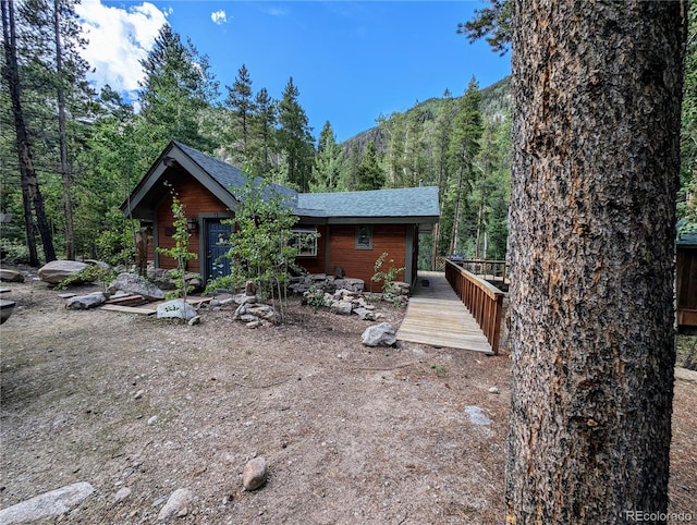 back of property with a deck with mountain view