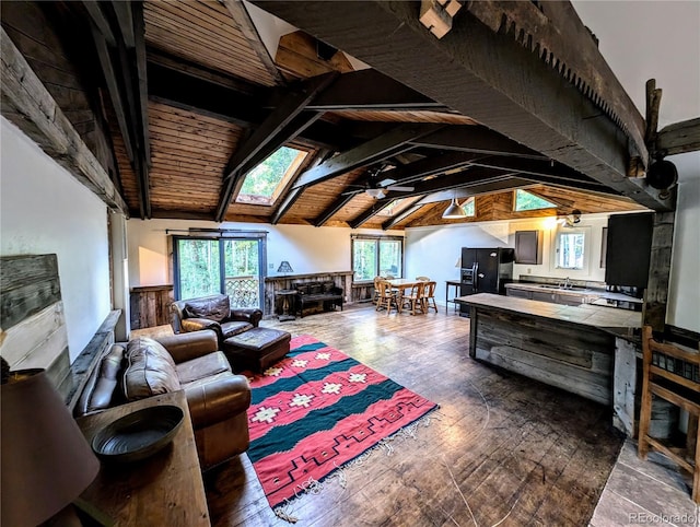 living room with sink, plenty of natural light, wood ceiling, and vaulted ceiling with skylight