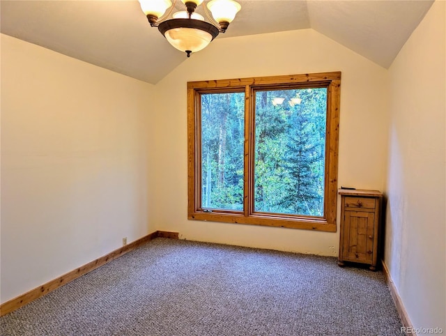 carpeted spare room with vaulted ceiling and a chandelier