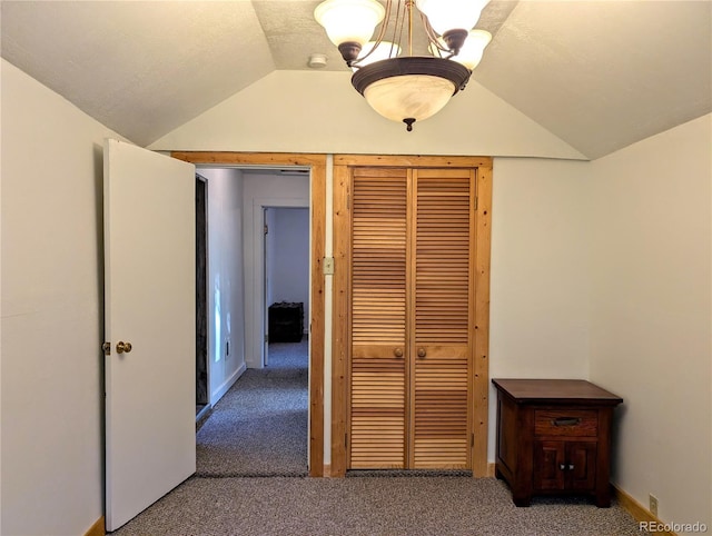 corridor with lofted ceiling and carpet