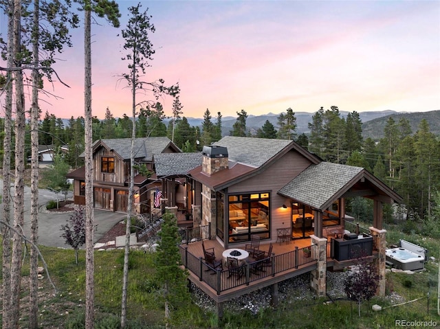 back house at dusk with a deck with mountain view