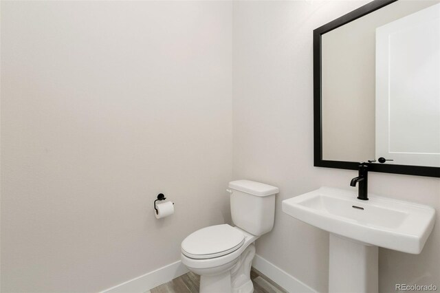 5835 Gianna Dr, Timnath, CO 80547 - bathroom with baseboards, toilet, wood finished floors, and a sink