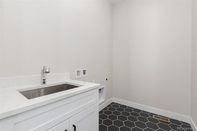 5835 Gianna Dr, Timnath, CO 80547 - washroom with electric dryer hookup, hookup for a washing machine, cabinet space, baseboards, and dark tile patterned flooring