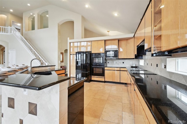 kitchen with black appliances, a spacious island, light tile patterned floors, sink, and high vaulted ceiling