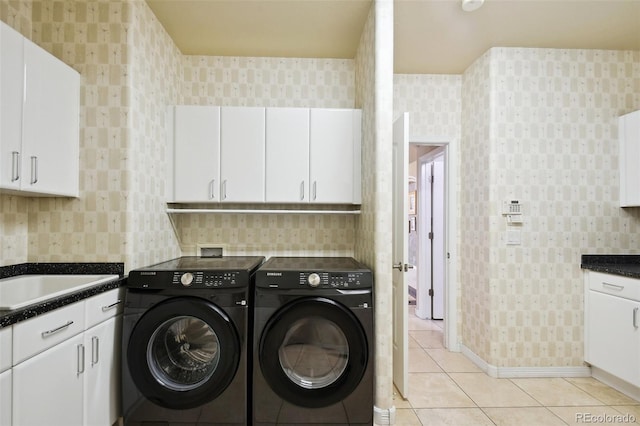 laundry area featuring independent washer and dryer, cabinets, sink, and light tile patterned floors