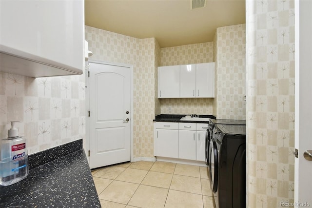 interior space featuring washer / clothes dryer, light tile patterned floors, white cabinetry, and sink