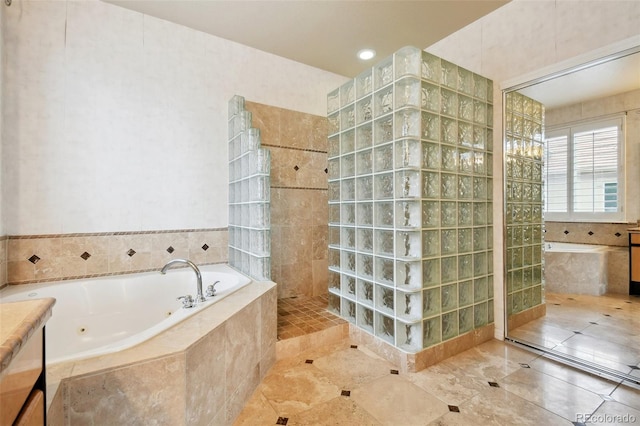 bathroom with vanity, tile walls, plus walk in shower, and tile patterned flooring