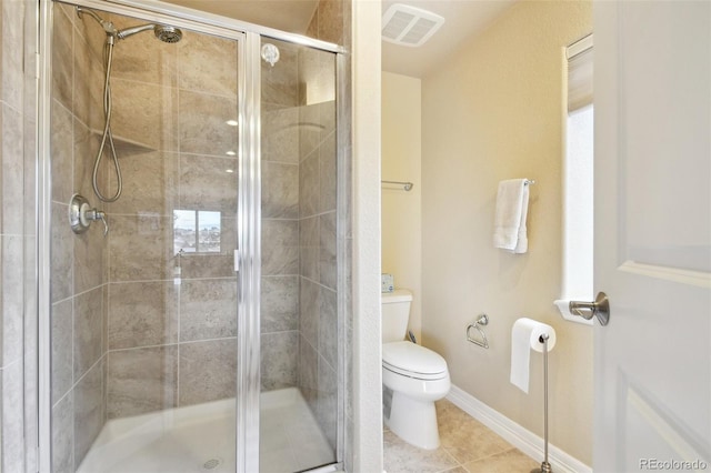 bathroom featuring tile patterned flooring, toilet, and an enclosed shower