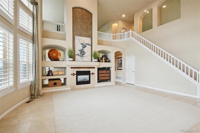 tiled living room with built in features and a high ceiling