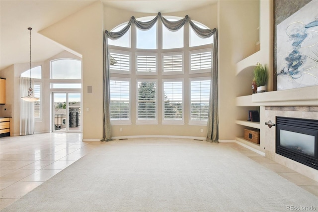 living room with light tile patterned floors, a tile fireplace, and a towering ceiling