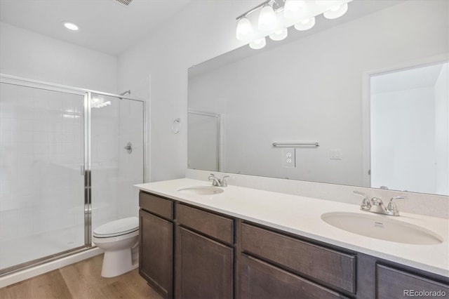 bathroom featuring hardwood / wood-style floors, vanity, toilet, and a shower with door