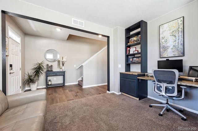 27130 E Maple Ave, Aurora, CO 80018 - home office with baseboards, built in desk, dark wood-style floors, and dark colored carpet