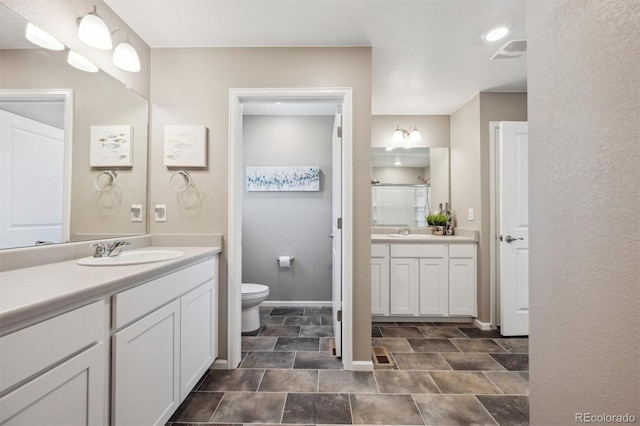 27130 E Maple Ave, Aurora, CO 80018 - full bathroom featuring toilet, two vanities, a shower stall, and baseboards