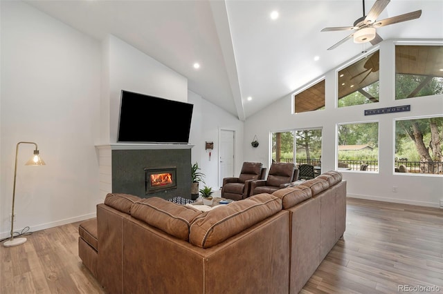 living room with ceiling fan, high vaulted ceiling, and light hardwood / wood-style floors