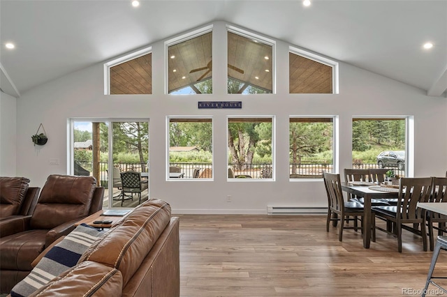 living room with high vaulted ceiling, light hardwood / wood-style flooring, baseboard heating, and ceiling fan