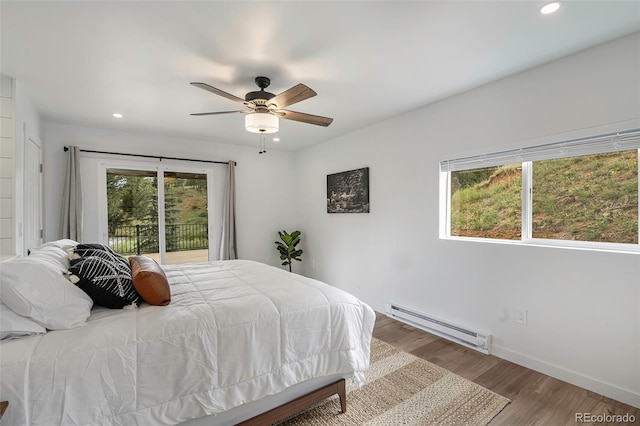 bedroom with baseboard heating, multiple windows, ceiling fan, and access to exterior